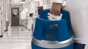 Medium blue BOC branded generic GENIE® gas cylinder in hand in laboratory setting