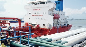 Detailed view of pipes loading petrochemicals onto a tanker.
